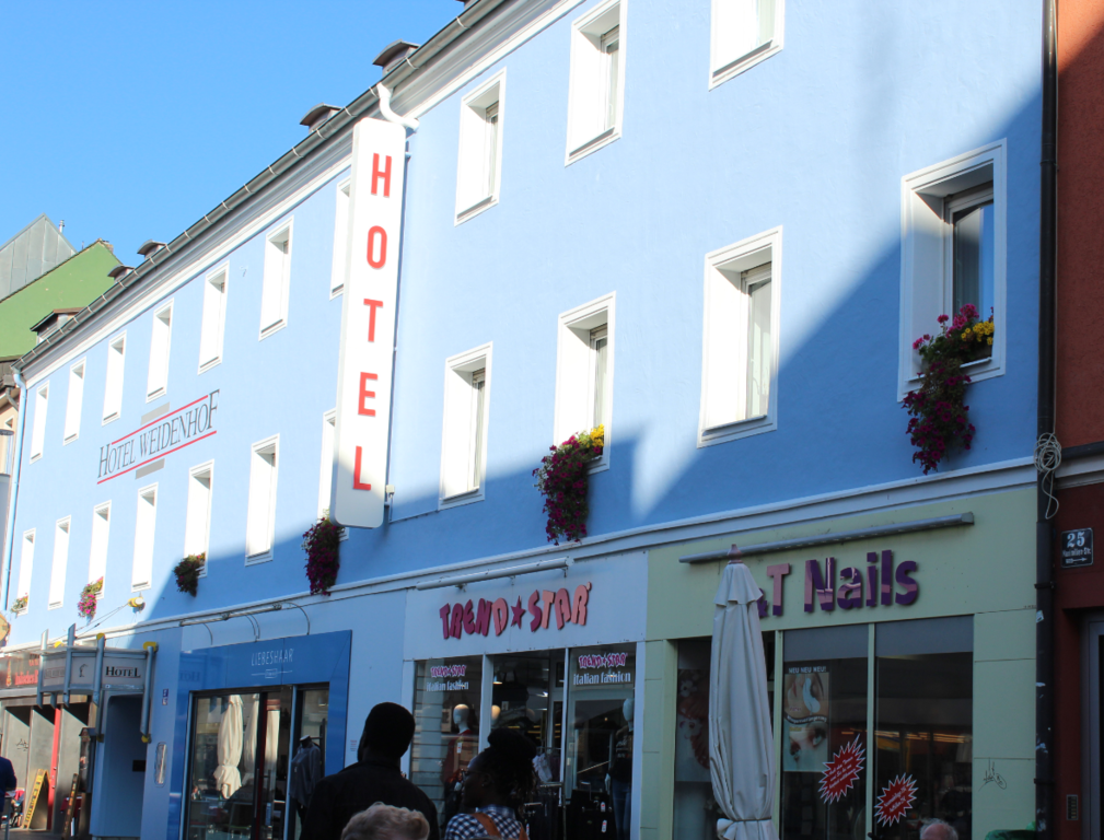 Sanierte gelbe Fassade eines großen Eckgebäudes in Regensburg