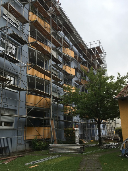 Frisch gestaltete Wohnanlage mit gelben Balkonen und Kirchturm in Regensburg