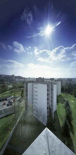 Sanierte gelbe Eckfassade unter blauem Himmel
