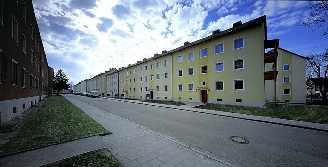 Gepflegte Wohnanlage mit gelber Fassade und blühendem Baum